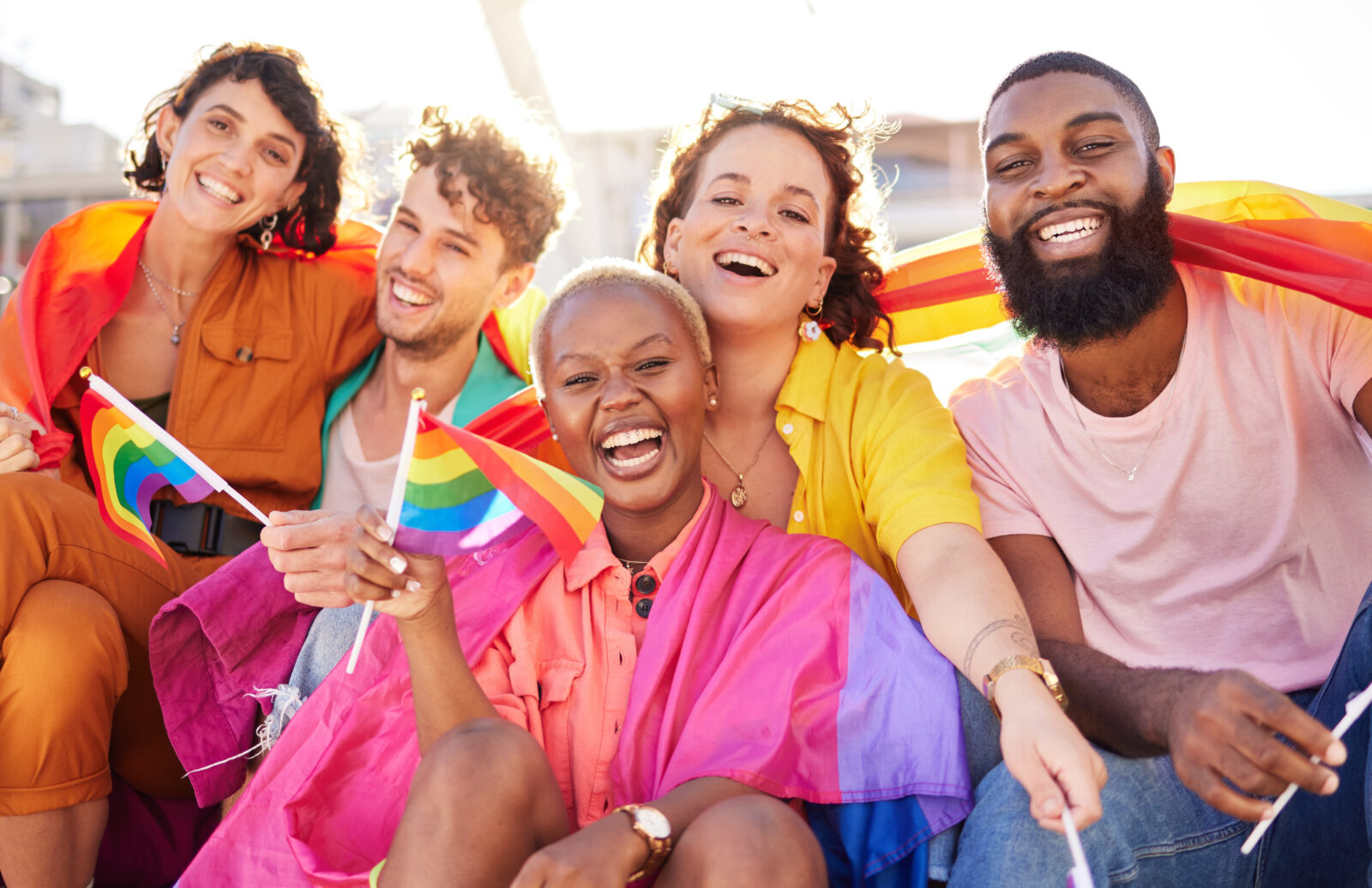 Portrait, diversity and rainbow flag for lgbtq community, freedom and smile for parade, support or solidarity. Friends, group or young people with non-binary, gay and lesbian with happiness and queer. 2023/06/AdobeStock_562906423.jpeg 