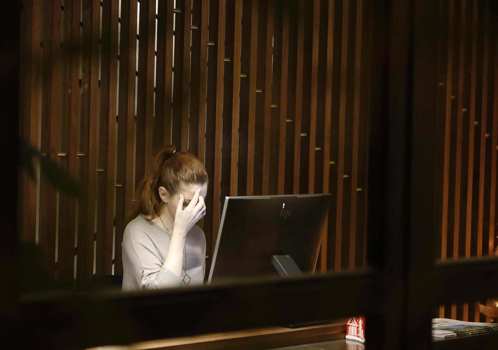 Woman sitting infront of laptop computer looking stressed