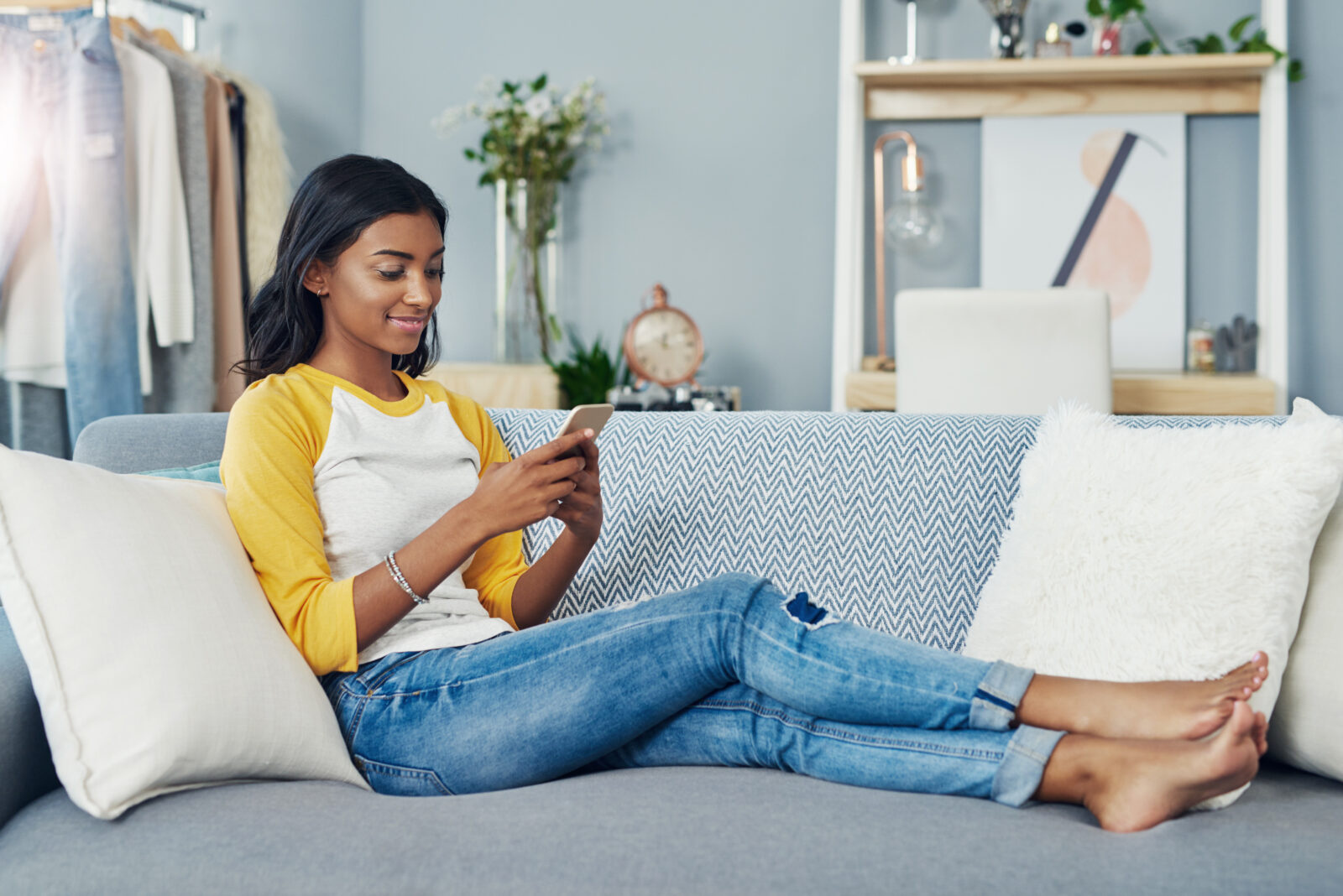 Sofa, phone and relax woman scroll, typing or message social network user, gen z contact or person. Lounge couch, home apartment and Indian girl reading cellphone, online shopping or app website info. 2024/03/AdobeStock_601900731.jpeg 