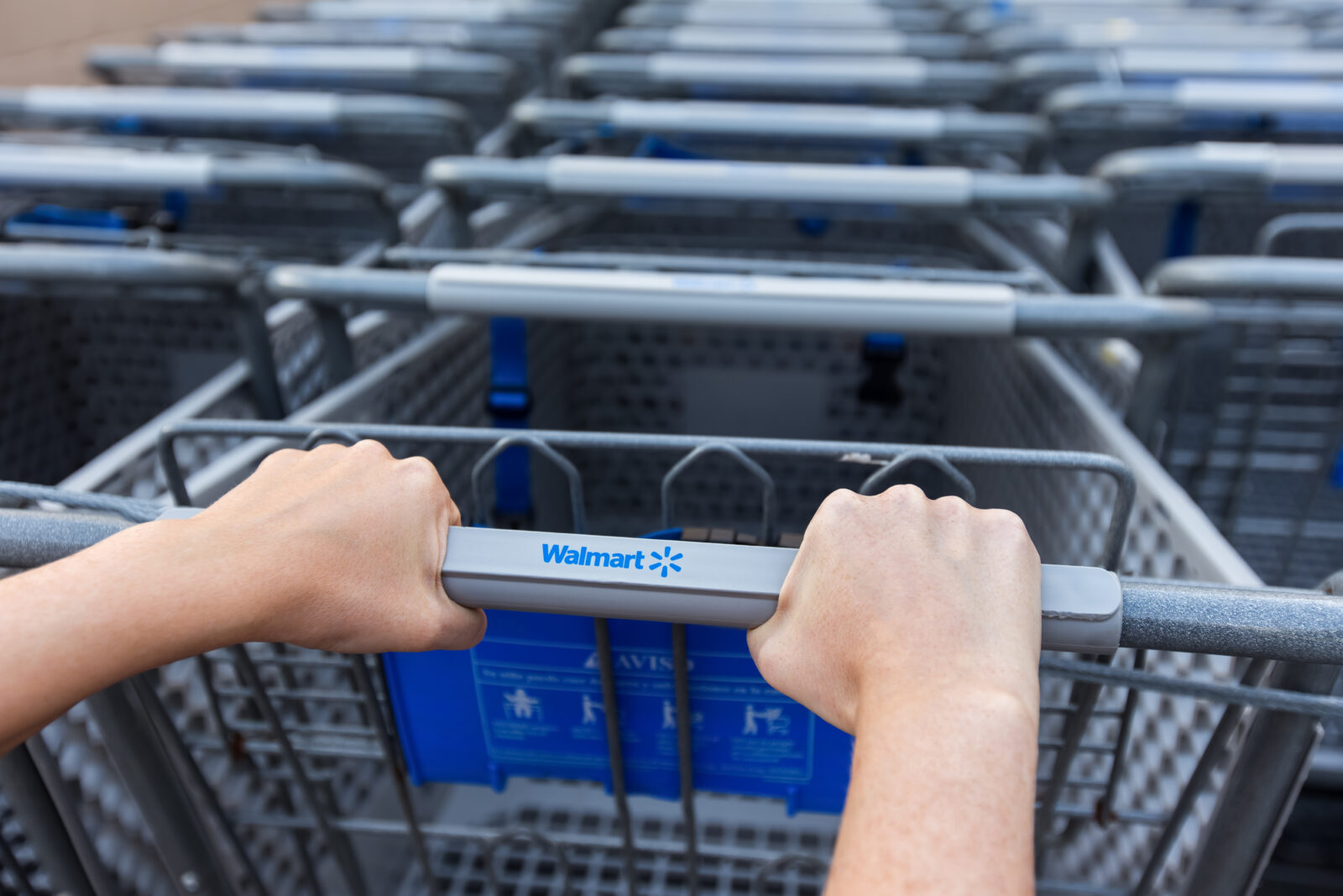 Cancun, Mexico - 9 February 2016: Woman taking shopping cart near Walmart supermarket. Closeup on female hand holding shop trolley with sign Walmart 2024/07/AdobeStock_292440062_Editorial_Use_Only.jpeg 