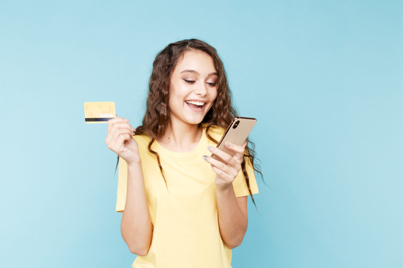 Young woman holding phone in the studio and making shopping online 2024/09/AdobeStock_315591510.jpeg 