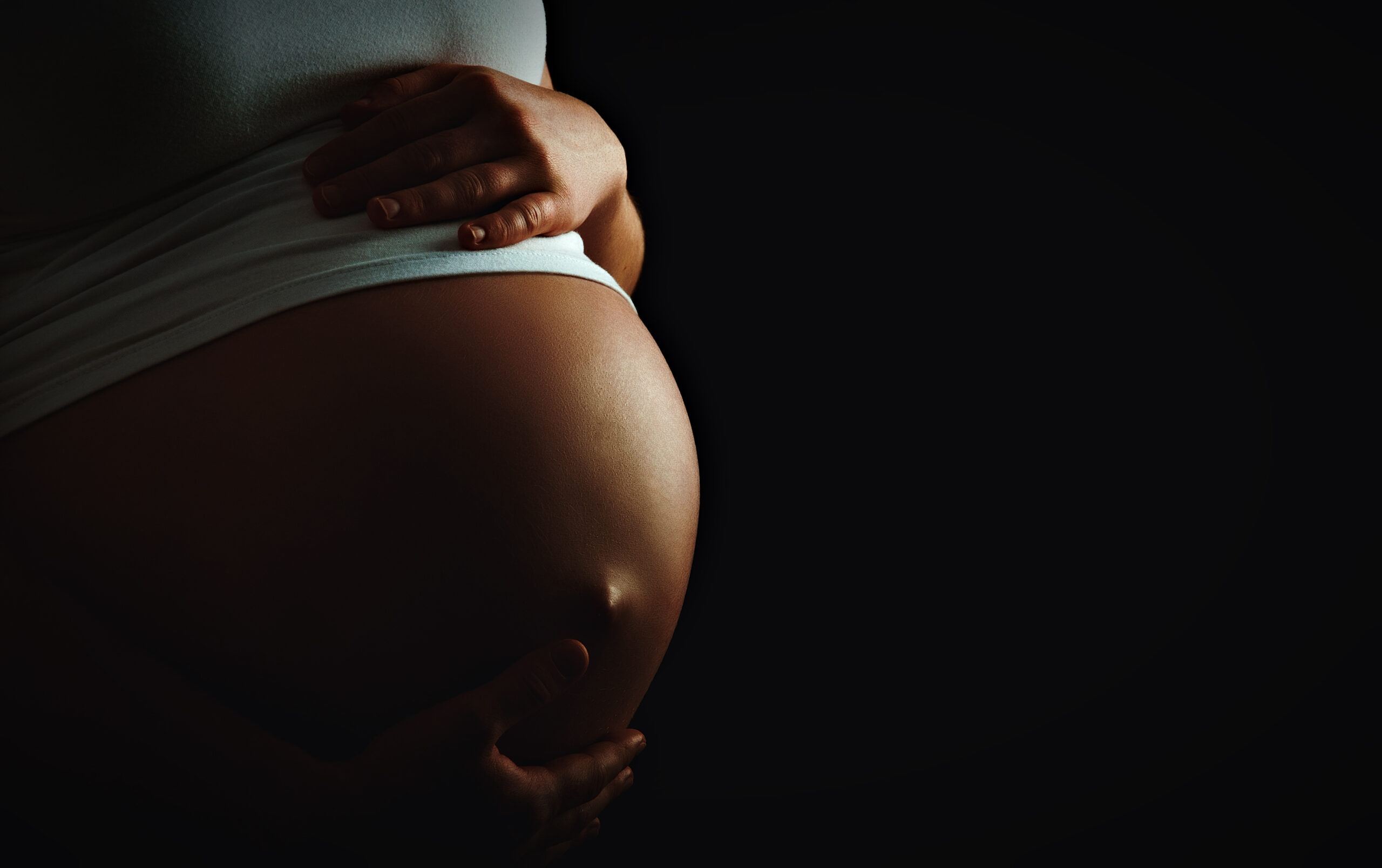 A pregnant woman holding her stomach
