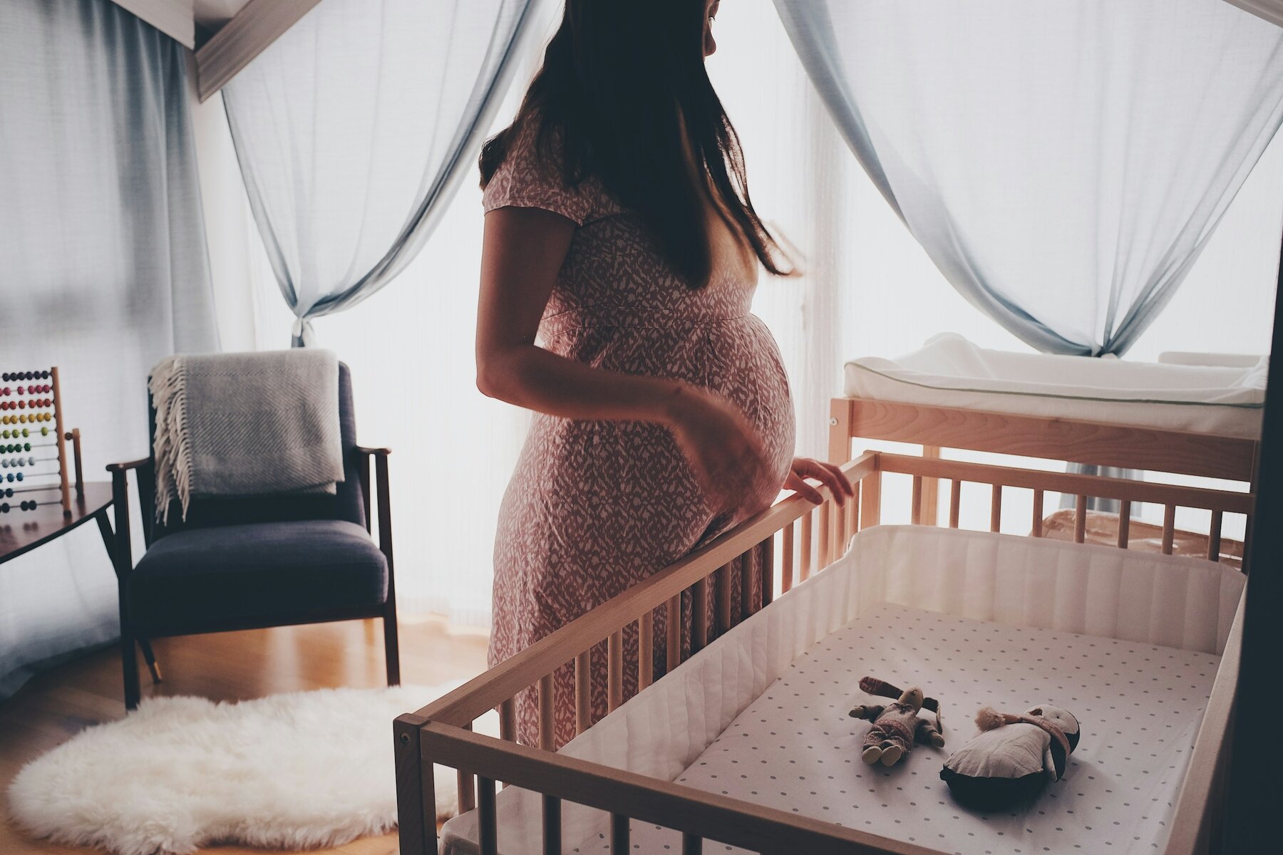 Pregnant woman looking at crib