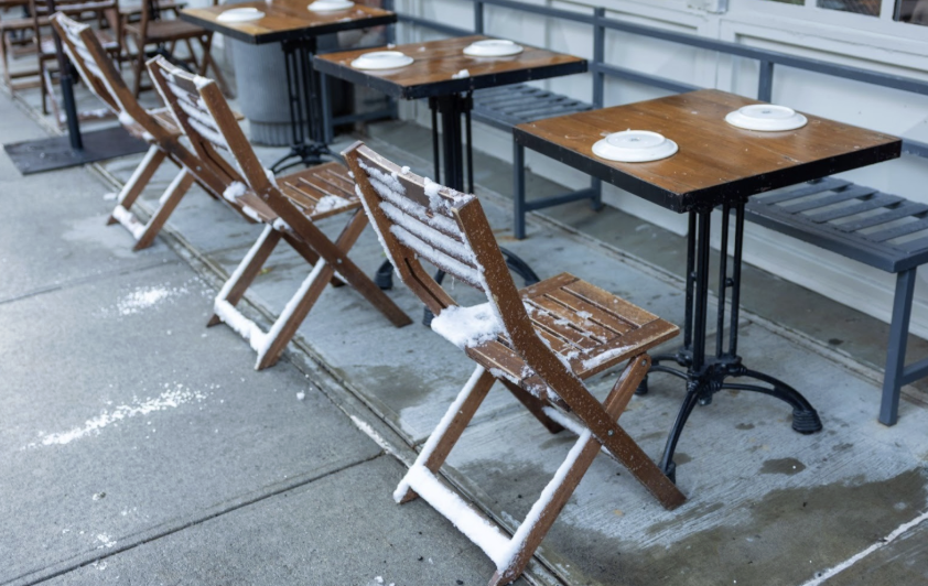 Photo of table with chairs and snow on the ground