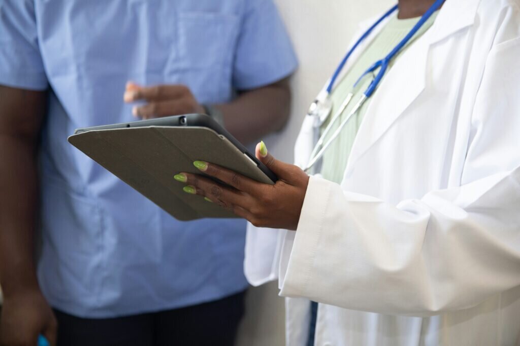 Doctor holding clipboard talking to patient
