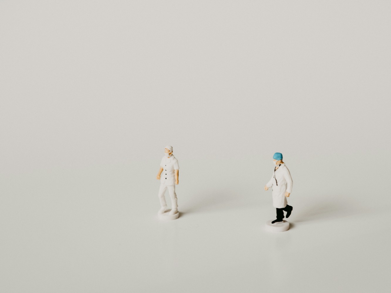 Two figurines standing in white space