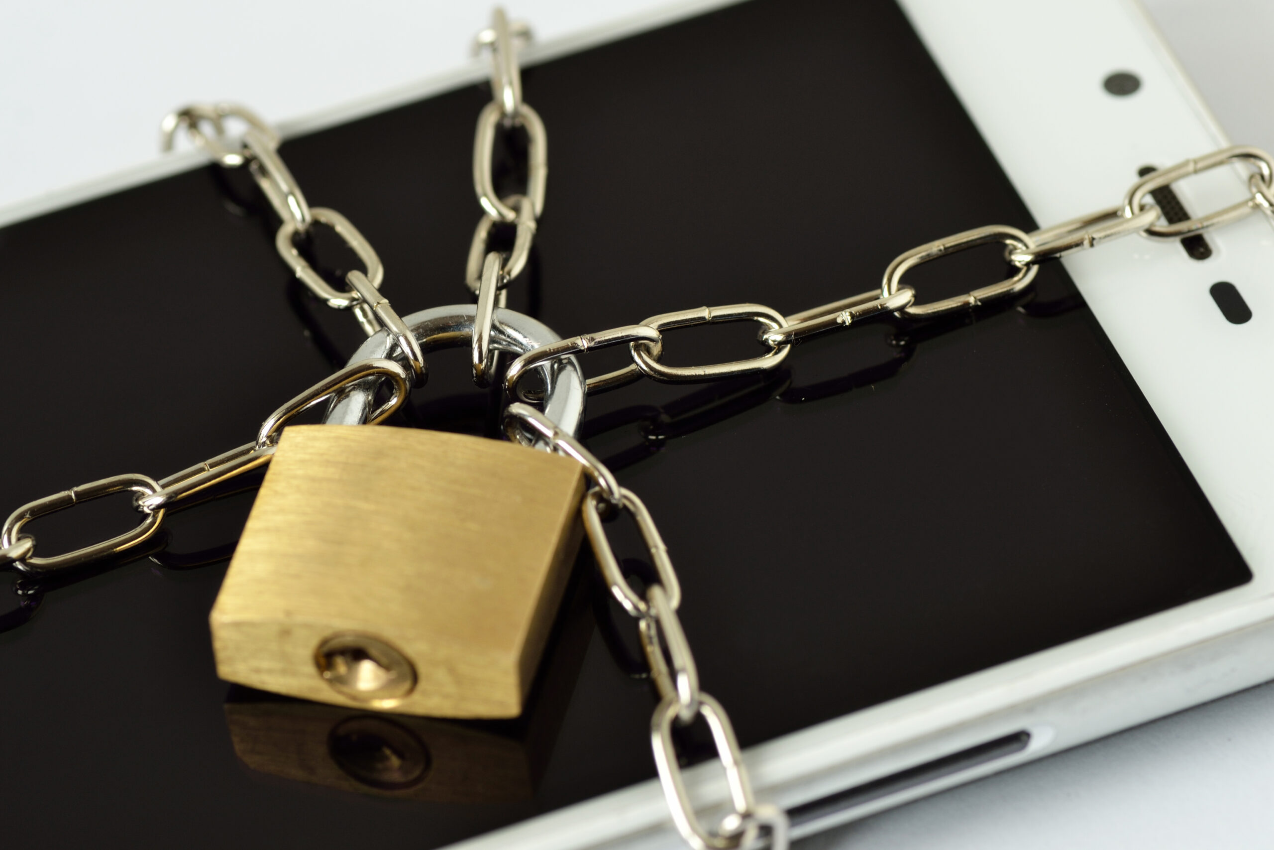 Close-up of smartphone locked with chain and padlock - Concept of mobile security and data privacy