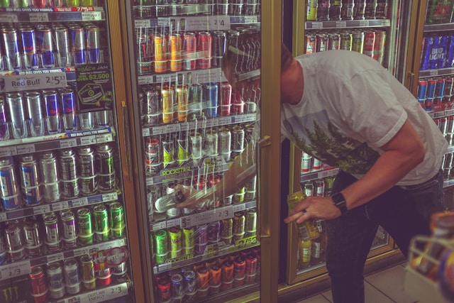 Person reaching into case of energy drinks